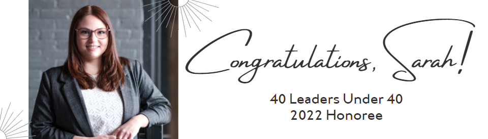 Picture of a woman with auburn hair in a white top and grey blazer standing in front of a grey brick wall. Text reads: Congratulations, Sarah! 40 Leaders Under 40 2022 honoree.