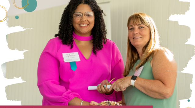 Woman in a bright pink dress smiles at the camera as she is handed a rolled certificate by a smiling woman in a green dress. Text reads: CFNIL Scholarships: 100+ scholarships for students of all backgrounds and educational aspirations, all awarded to students right here in northern Illinois!