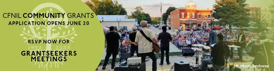 picture of a band playing on an outdoor stage in front of a crowd of people