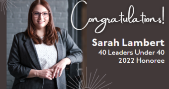 Picture of a woman with auburn hair in a white top and grey blazer standing in front of a grey brick wall. Text reads: Congratulations, Sarah! 40 Leaders Under 40 2022 honoree.